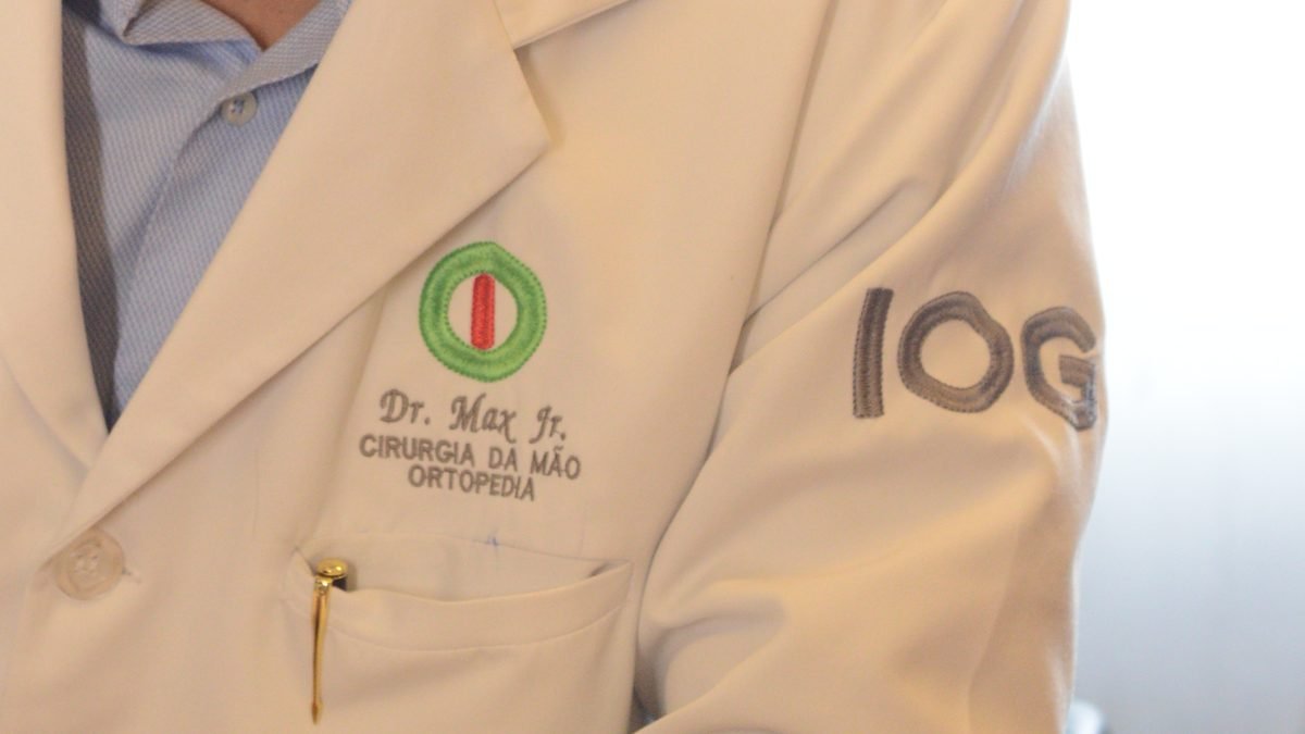 Jaleco do Dr. Max Lopes Jr com o bordado Cirurgia da Mão e Ortopedia